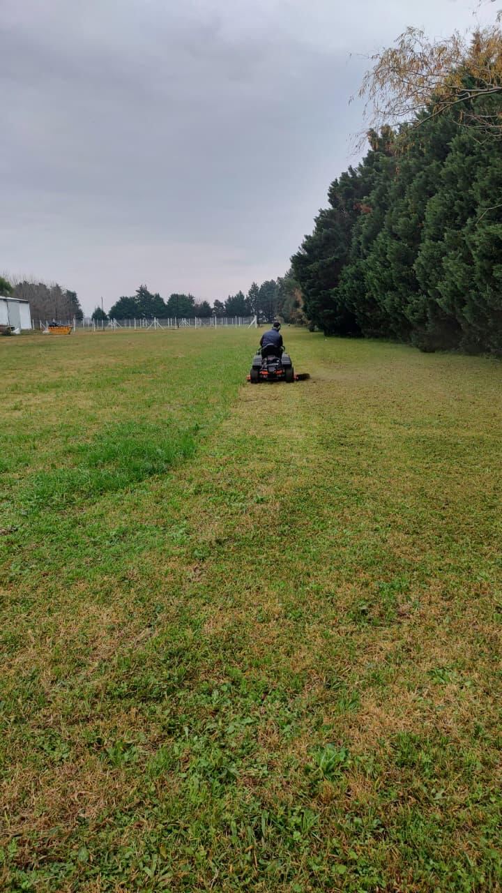 Corte de césped con tractor en un predio grande